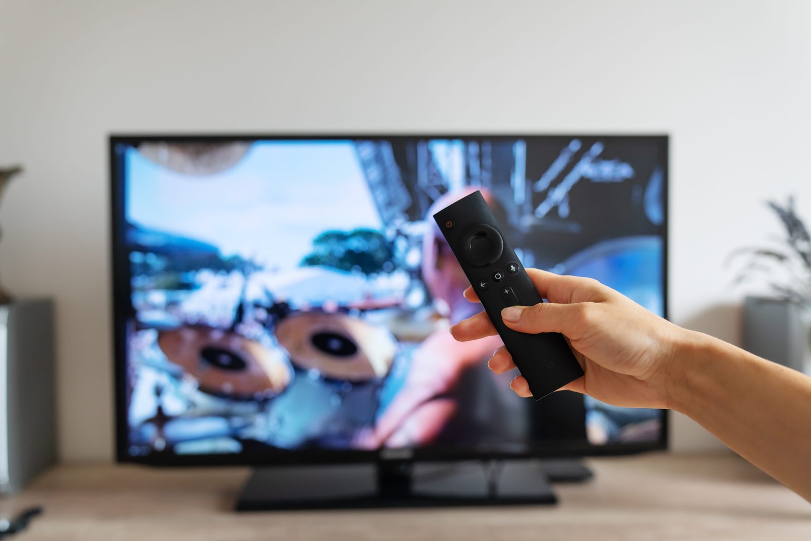 Hand holding a TV remote — common remote control faults serviced by Silman TV Repairs
